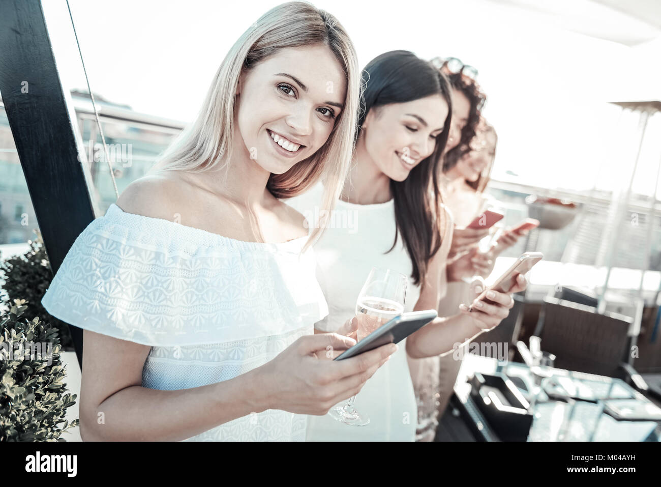 Pretty nice-looking girl keeping cellphone and smiling Stock Photo - Alamy