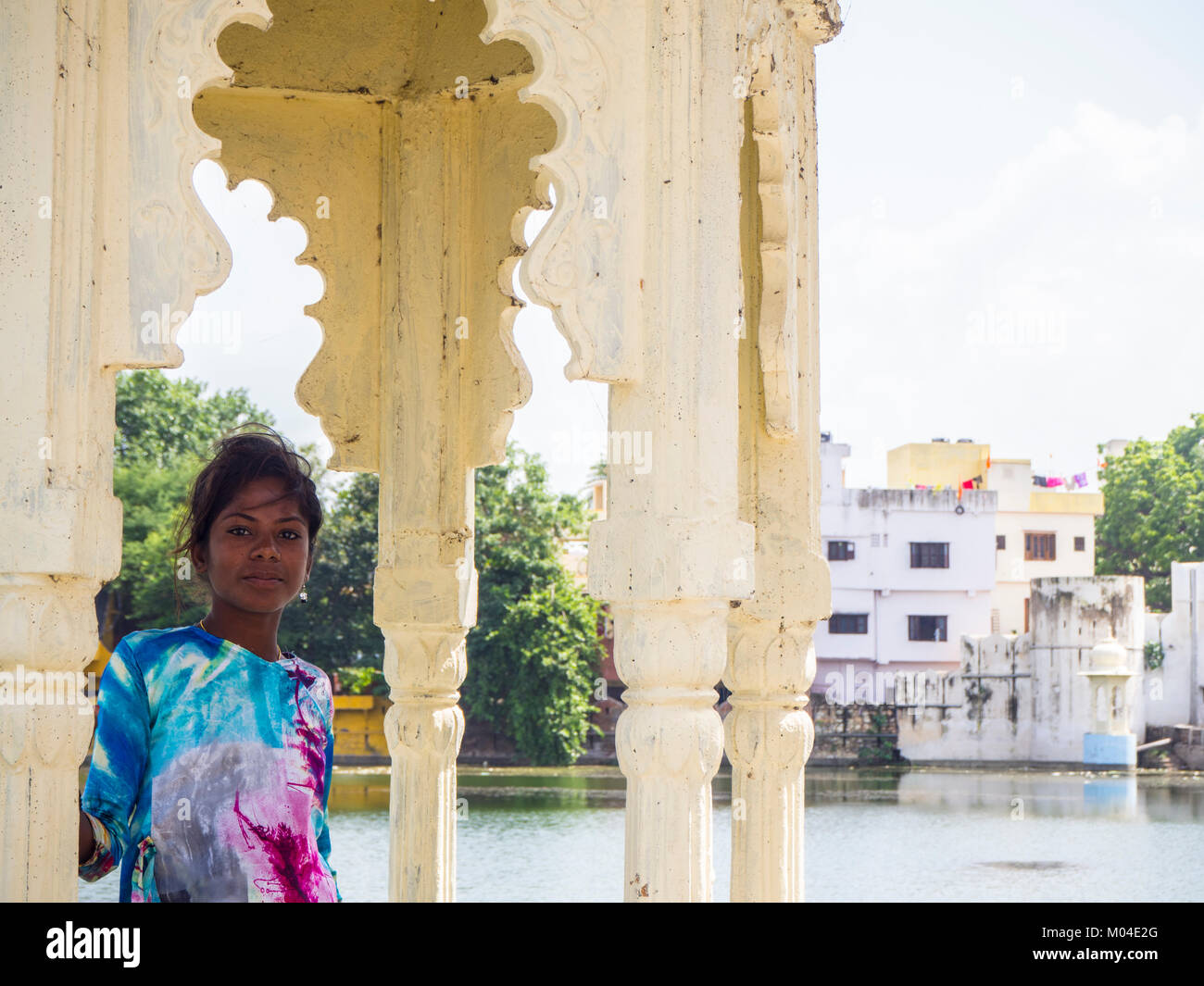A colorful photograph of a beautiful local Indian girl against the backdrop of the old city and the lake in Udaipur Stock Photo