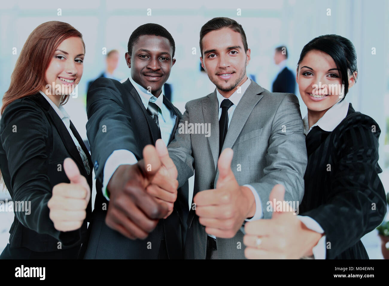 Happy business team with thumbs up in the office Stock Photo - Alamy