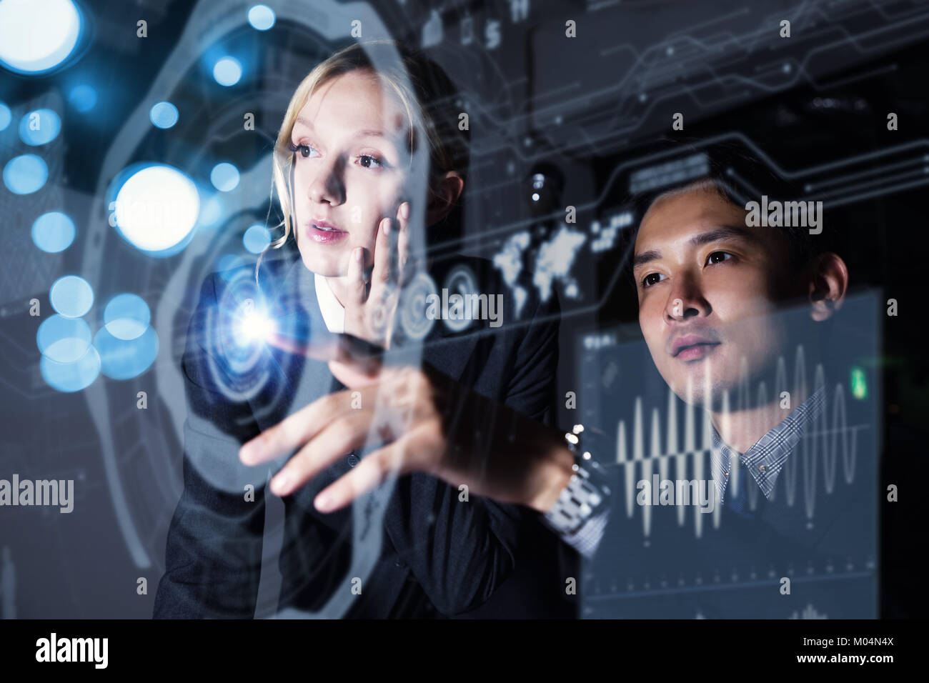 Two business persons in front of futuristic display. Social networking concept. Stock Photo