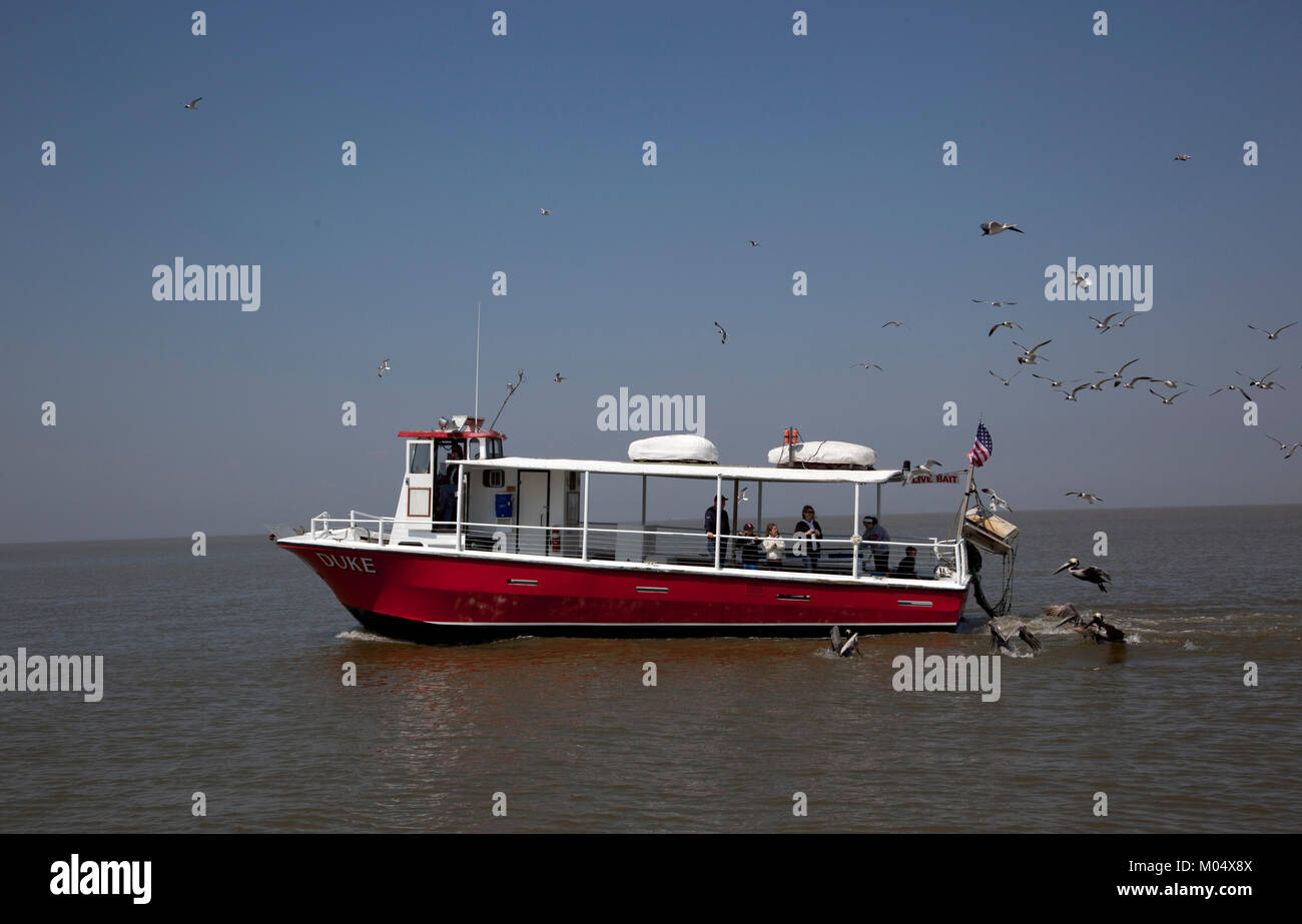 Ferries, boats and oil rigs all co-exist on Mobile Bay in Alabama Stock Photo