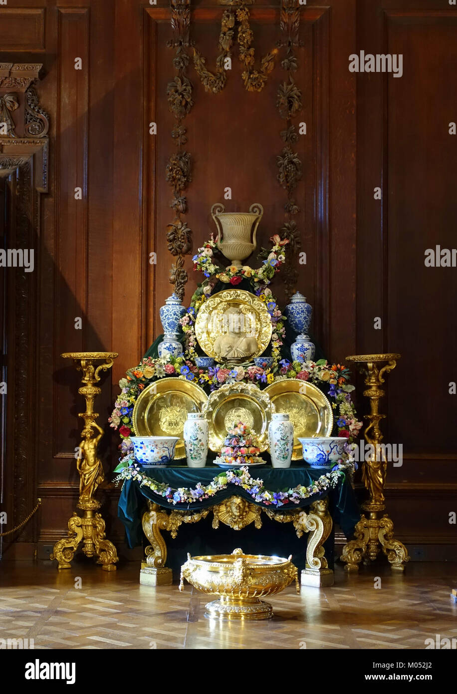 The buffet in the Great Chamber of Chatsworth House, inspired by Alexandre François Desportes' *Still Life with Silver*, showcases fine ceramics, silver gilt, and wax fruit and flowers, reflecting 18th-century European decorative art. Stock Photo