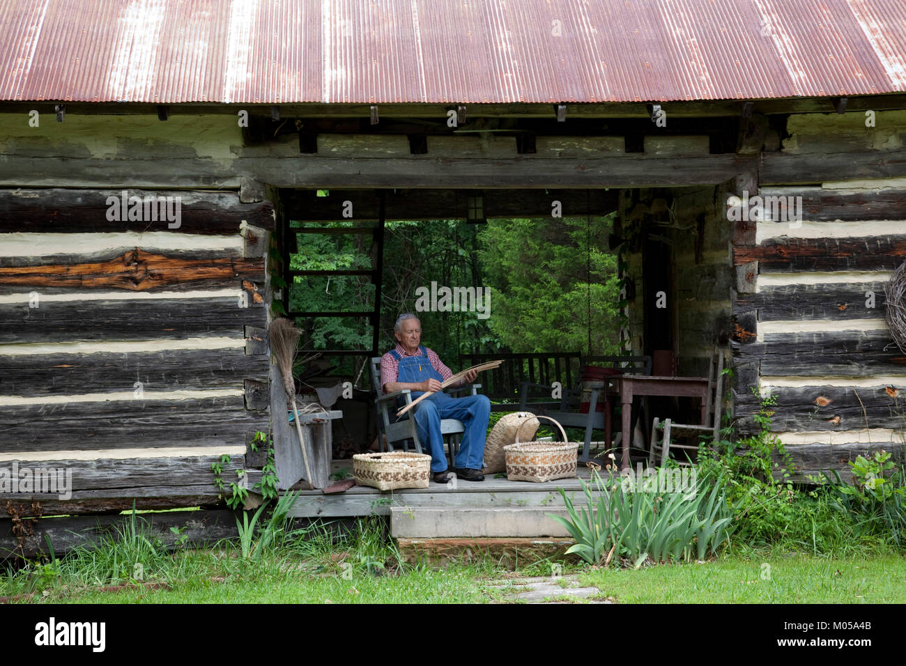 Basket weaver in Log Cabin Stock Photo