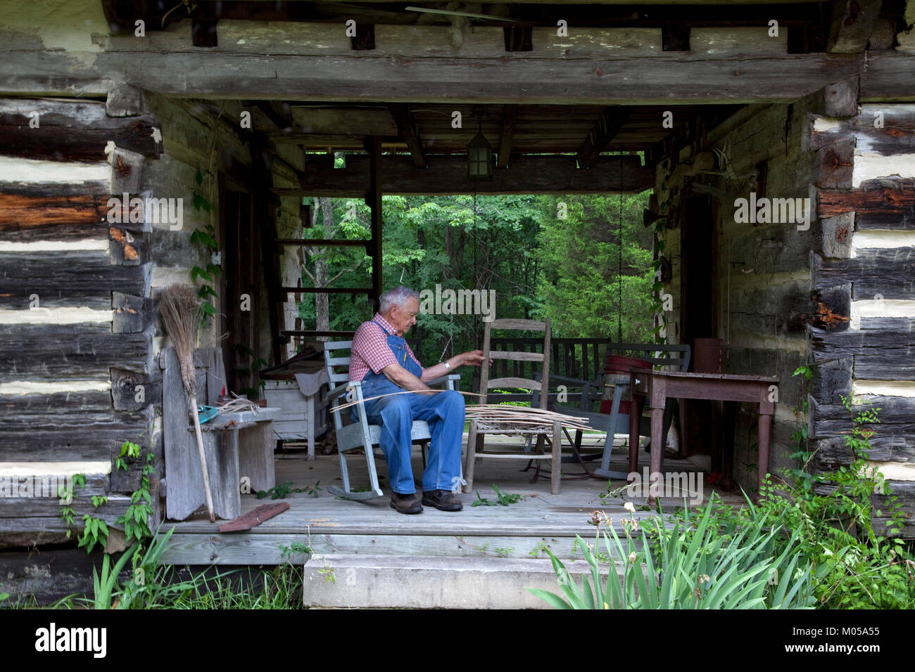 Basket weaver in Log Cabin Stock Photo