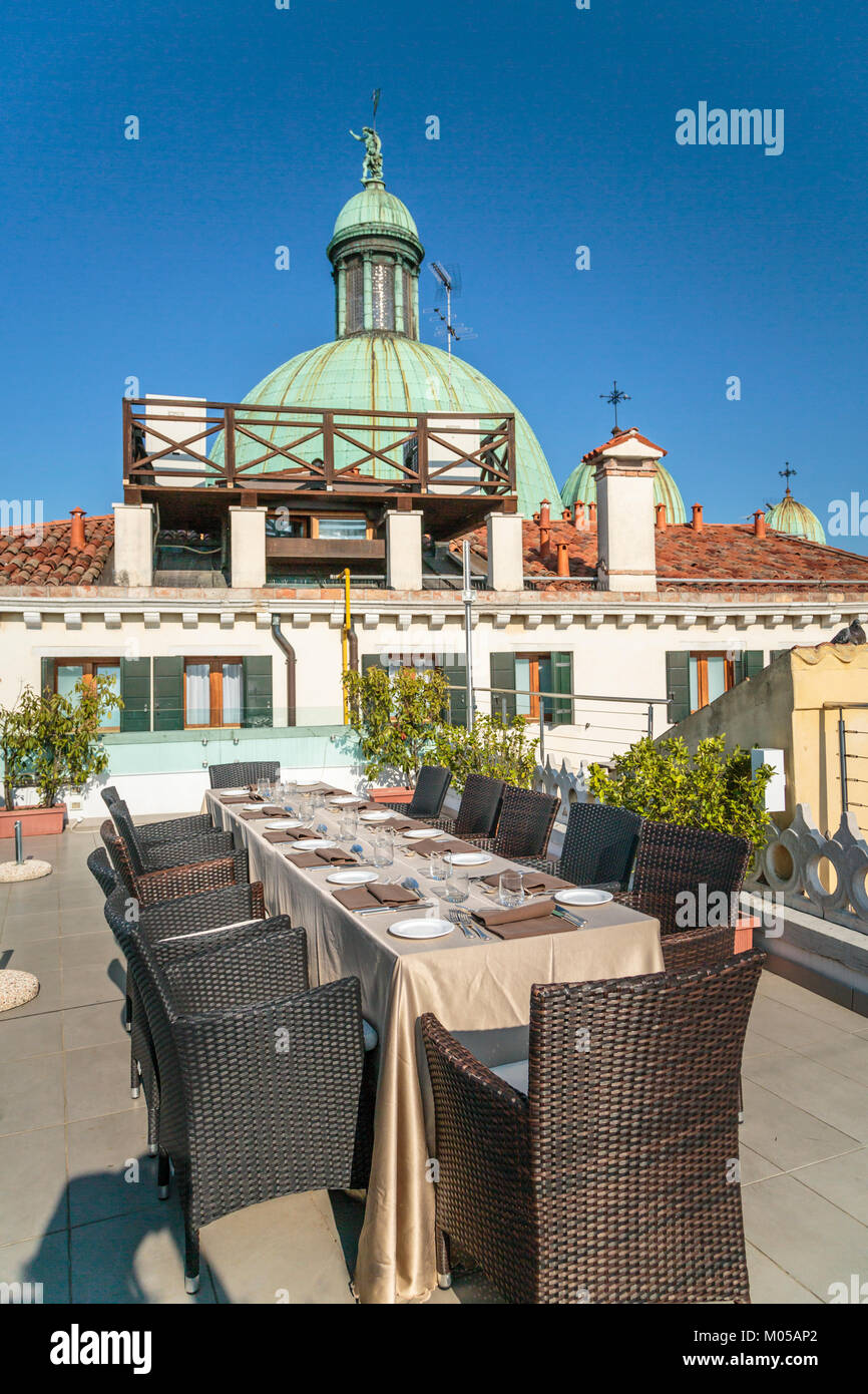 Church domes of the Church of San Simeone Piccolo and rooftop tables at the Hotel Carlton along the Grand Canal in Veneto, Venice, Italy, Europe. Stock Photo