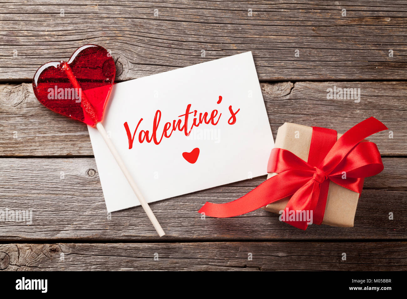 Valentines day greeting card, candy heart and gift box on wooden table ...