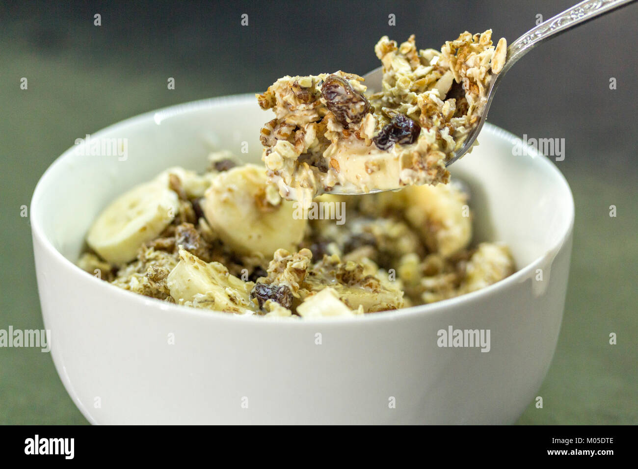 Breakfast idea bowl of cerial muesli with sliced banana and milk one of your five a day fruits and carbohydrates for slow release energy and it's nice Stock Photo