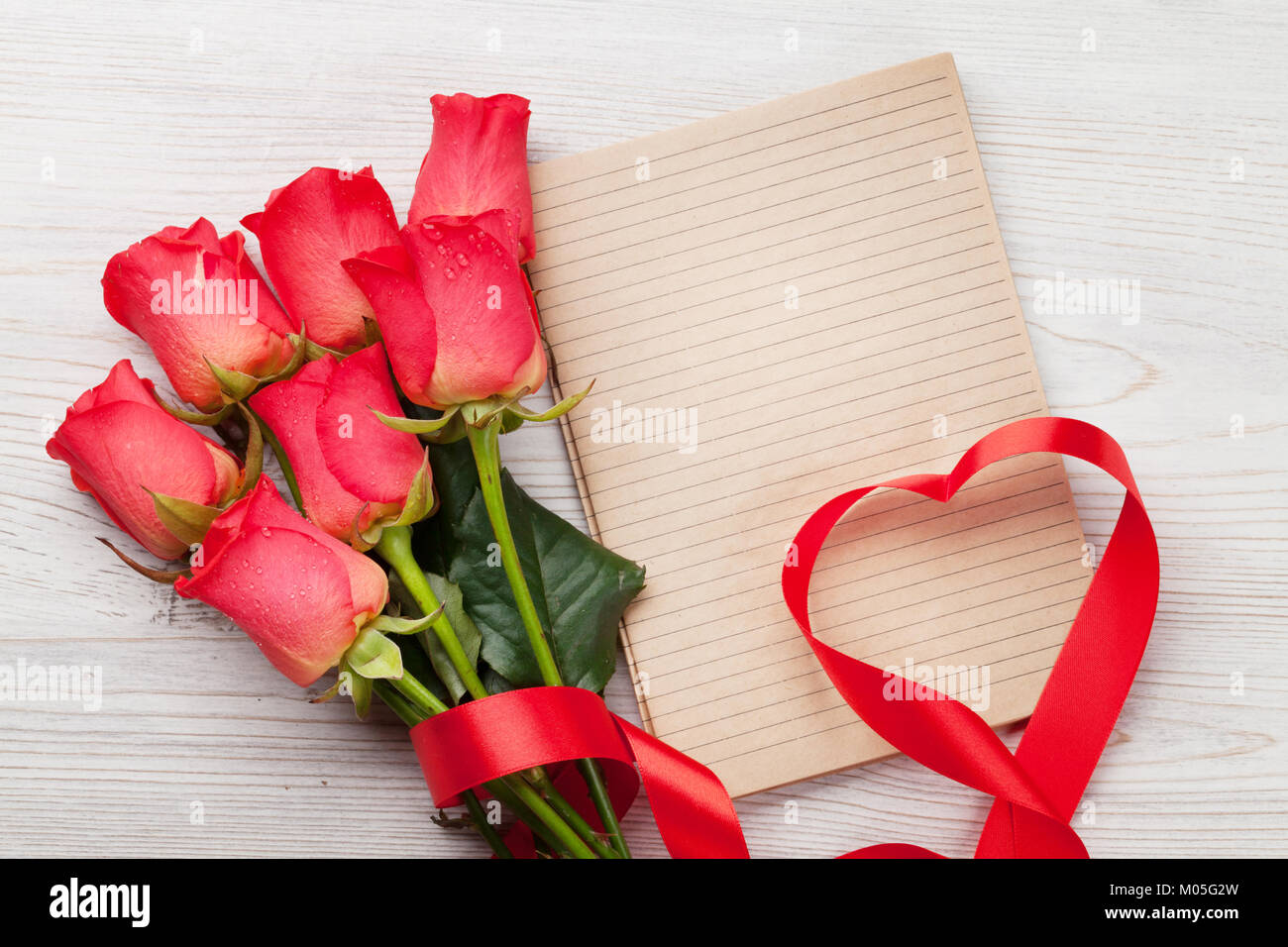 Valentines day greeting card with red roses and heart shaped ribbon on ...