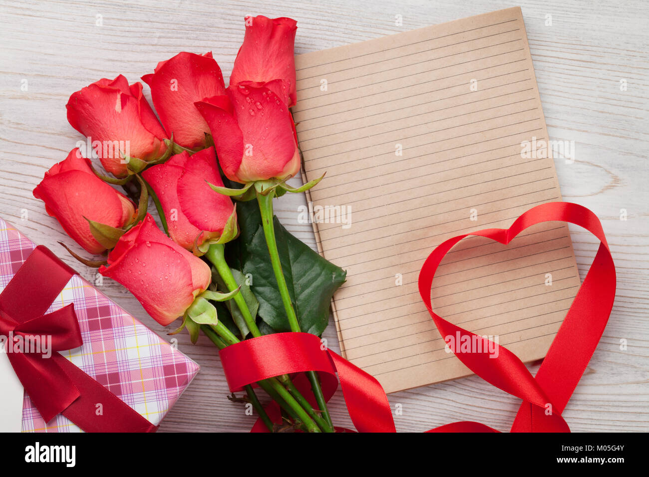 Valentines day greeting card with red roses and heart shaped ribbon on ...