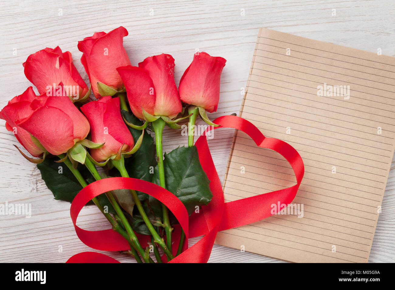 Valentines day greeting card with red roses and heart shaped ribbon on ...