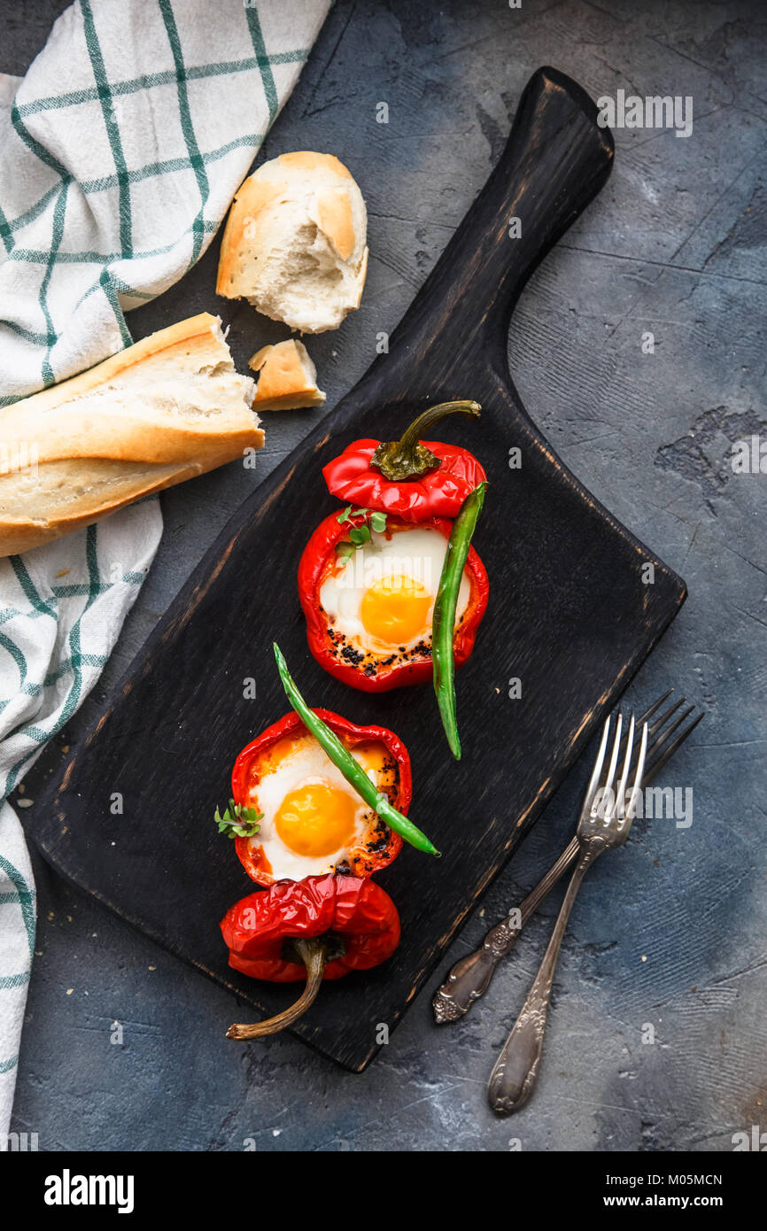 Baked red peppers stuffed with eggs and sausage with bread and green