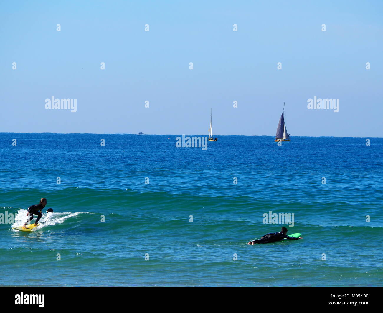 wave surfers at the sea on a perfect clear day Stock Photo