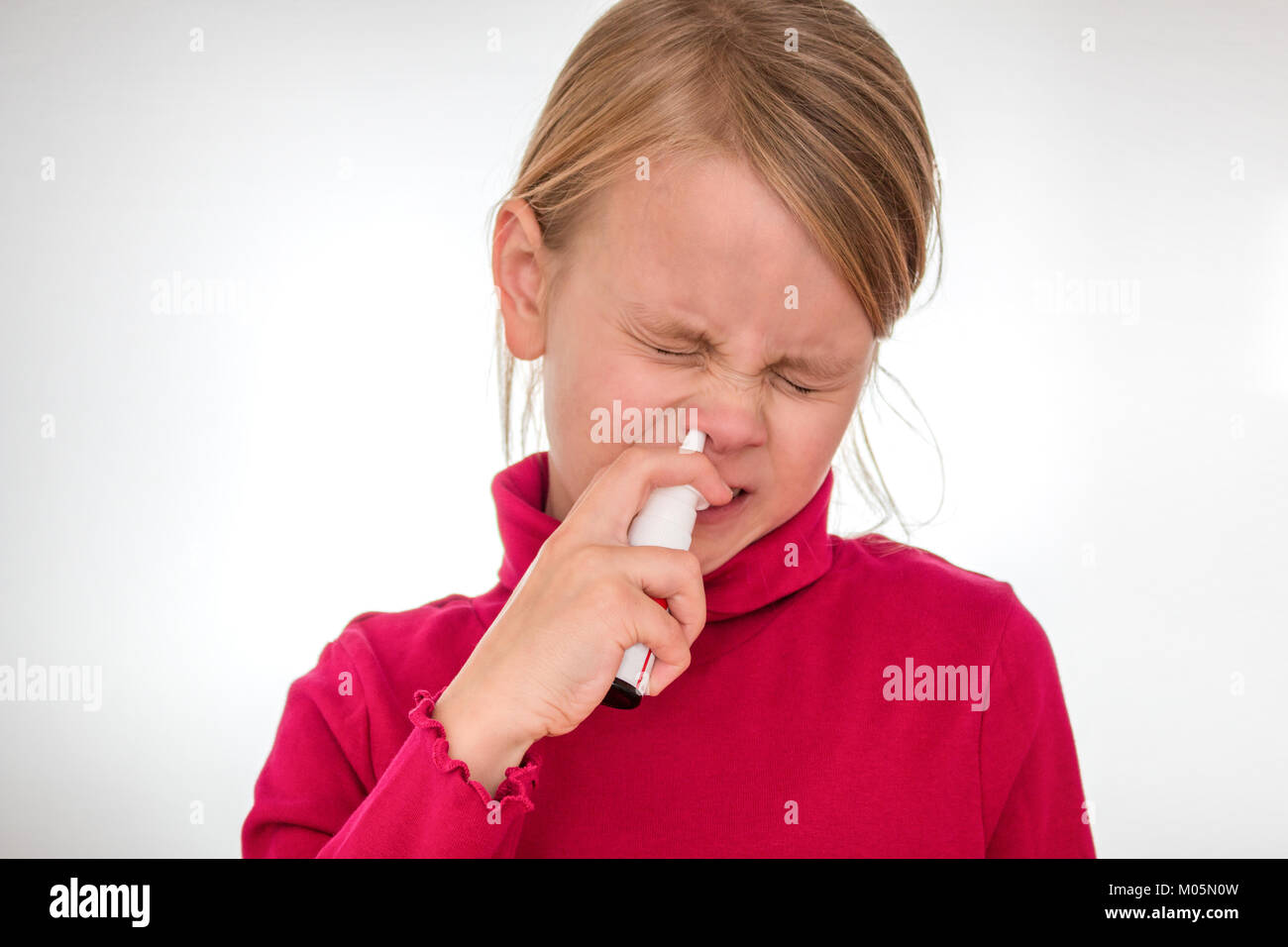 A girl overcomes his fear and uses nasal spray Stock Photo