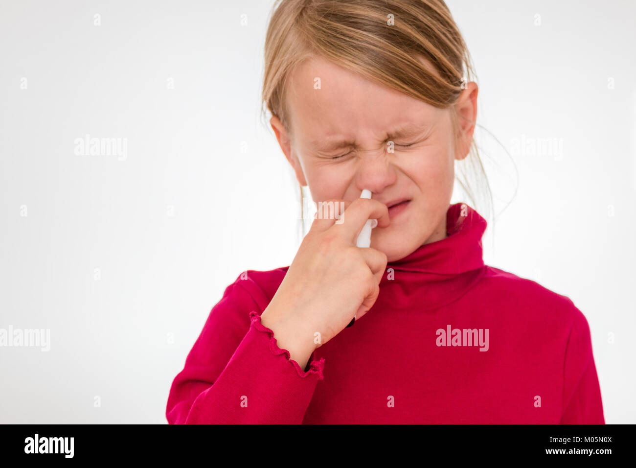 A girl overcomes his fear and uses nasal spray Stock Photo