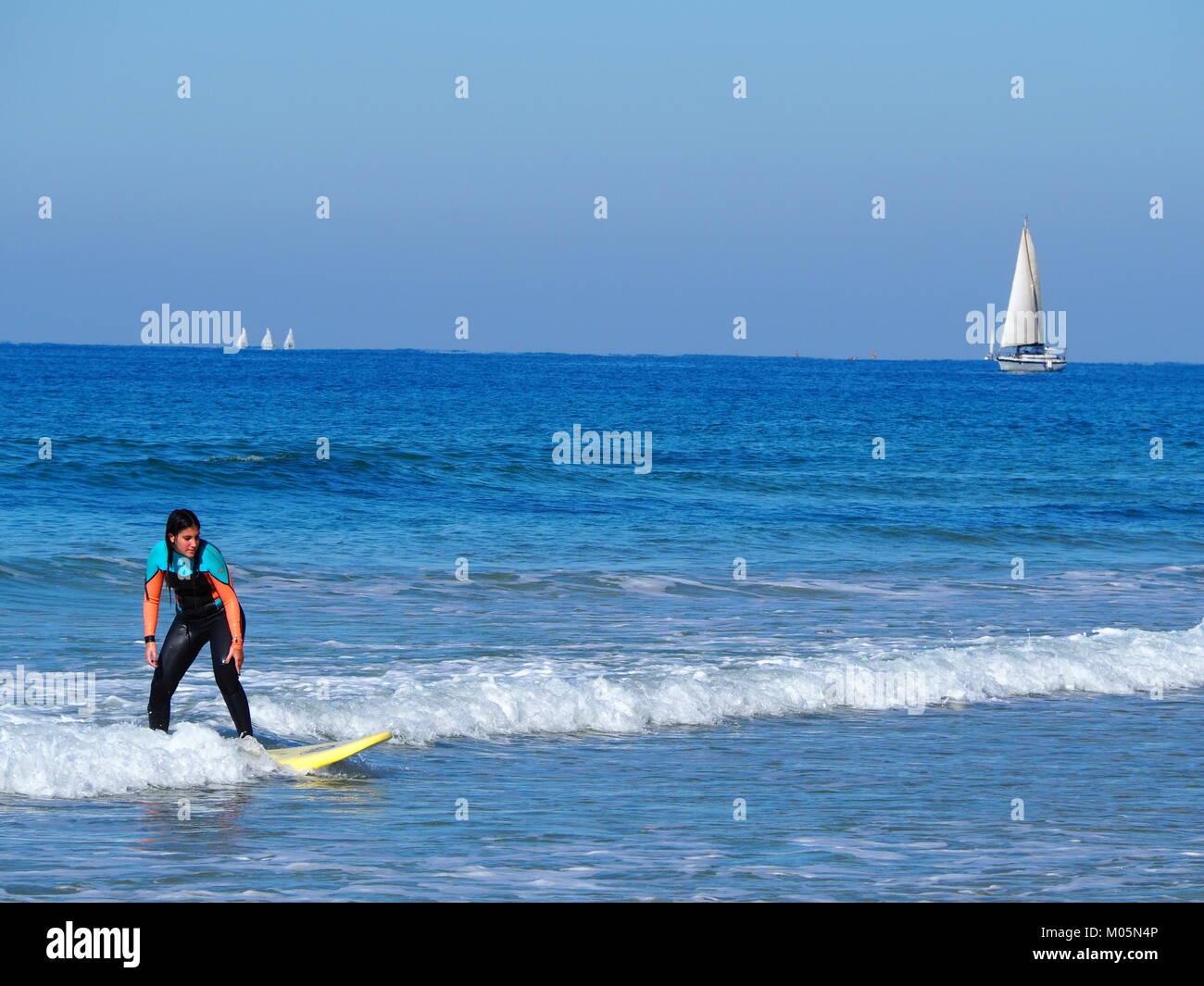 wave surfer girl at the sea on a perfect clear day Stock Photo