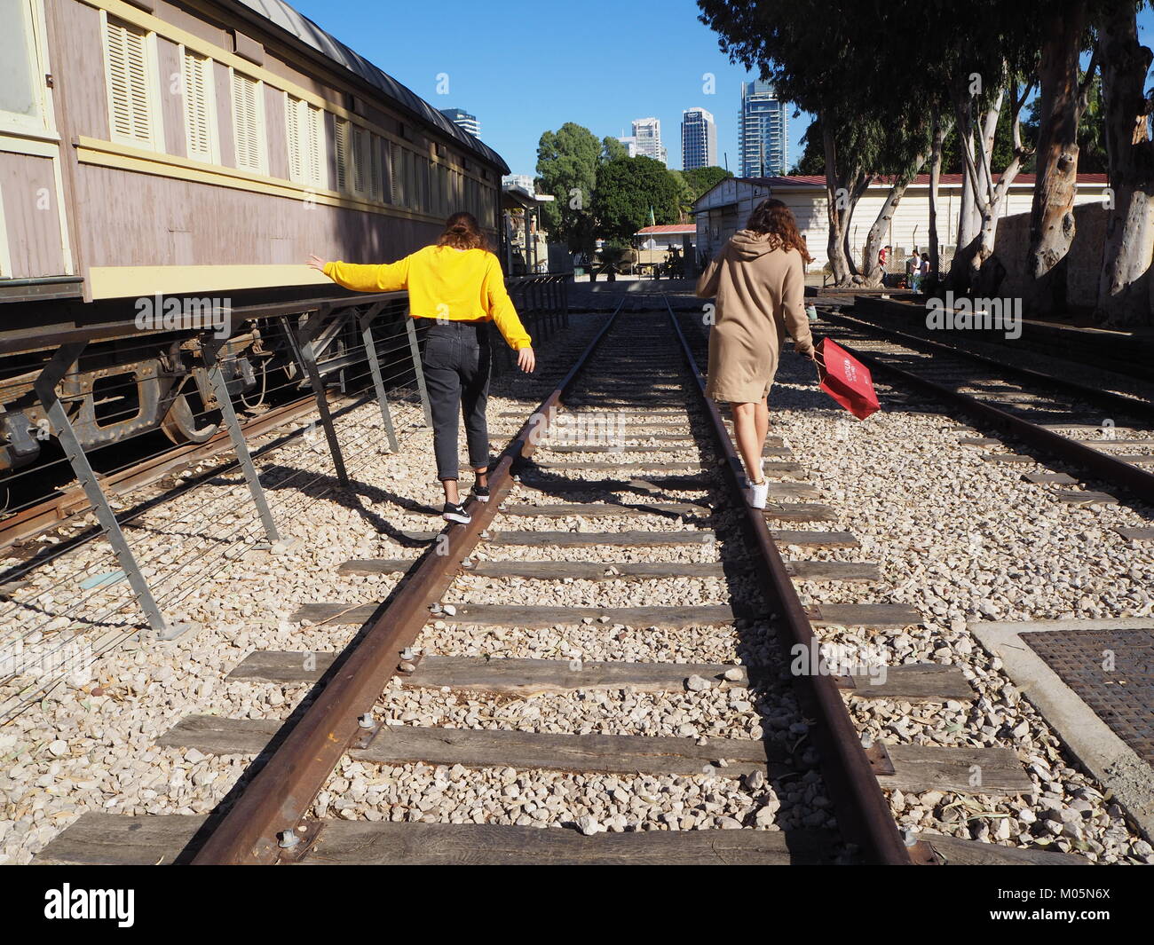 teen girls are walking side by side on rails Stock Photo