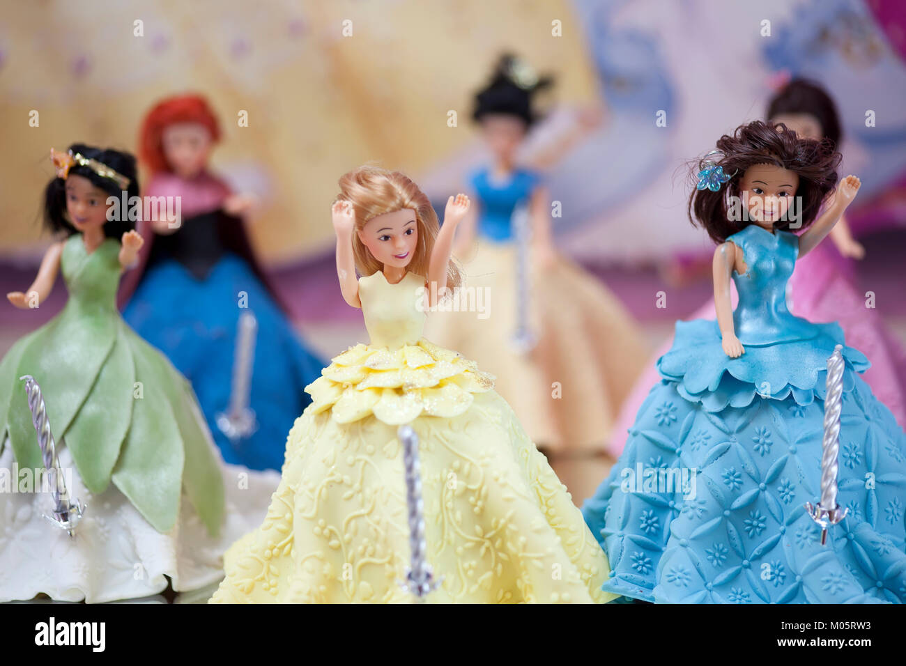 Few disney character dolls used as cake toppers on a birthday cake for a celebration Stock Photo