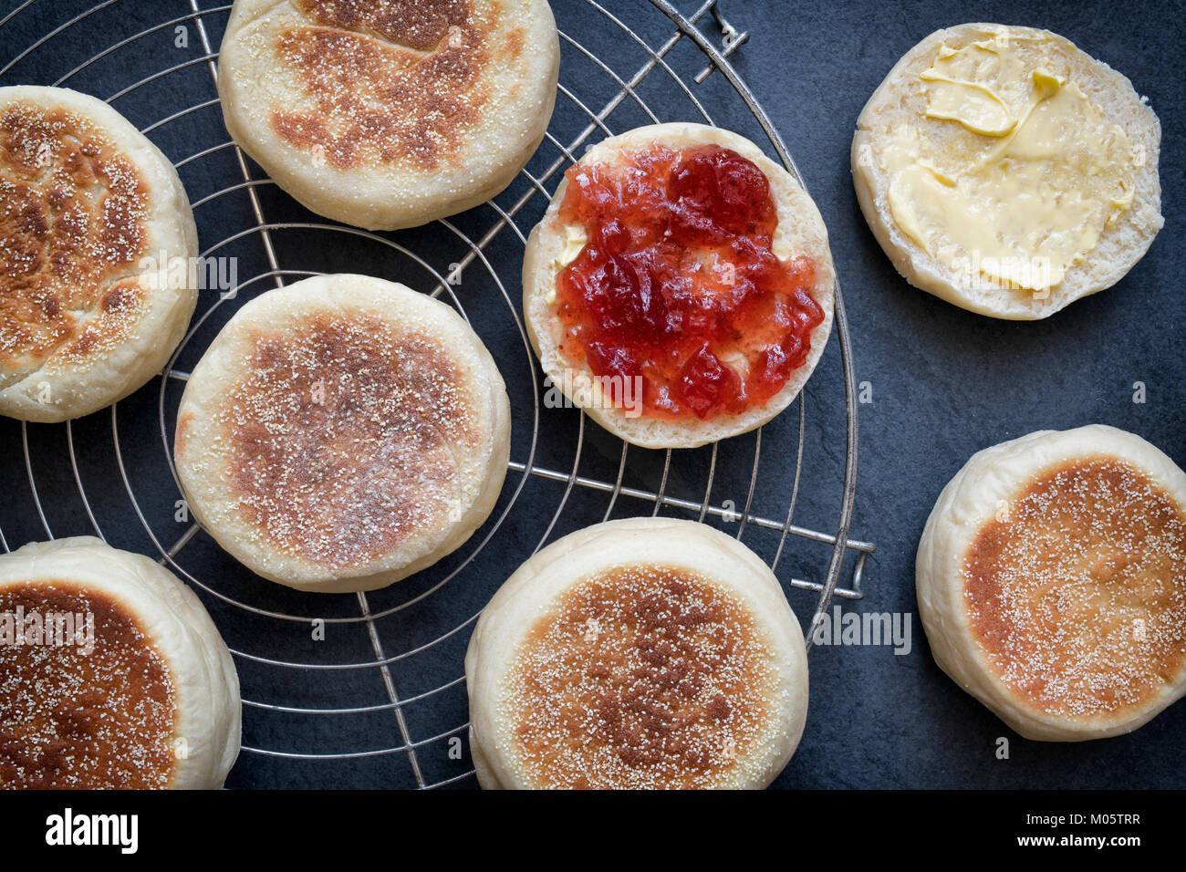 English Muffins with strawberry jam on a slate background Stock Photo