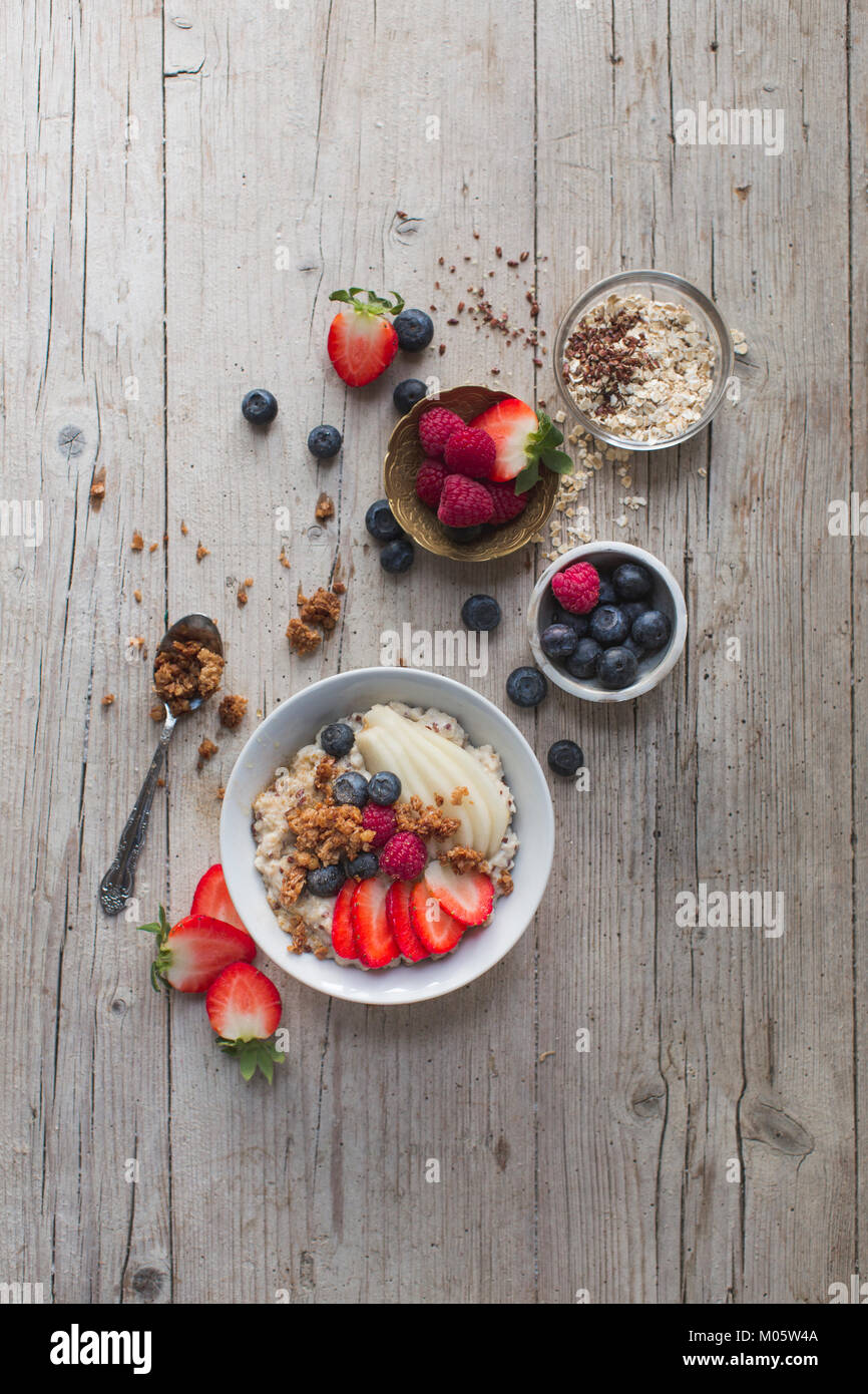 oat cereals porridge with fresh fruits on a wooden table Stock Photo