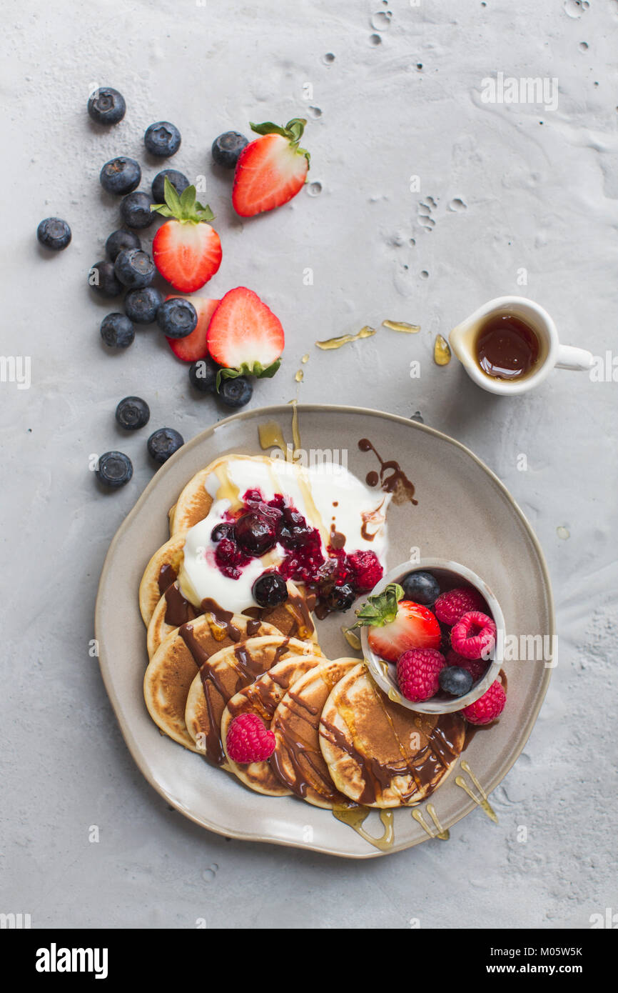 Pancakes with fresh fruits and chocolate sauce and maple syrup Stock
