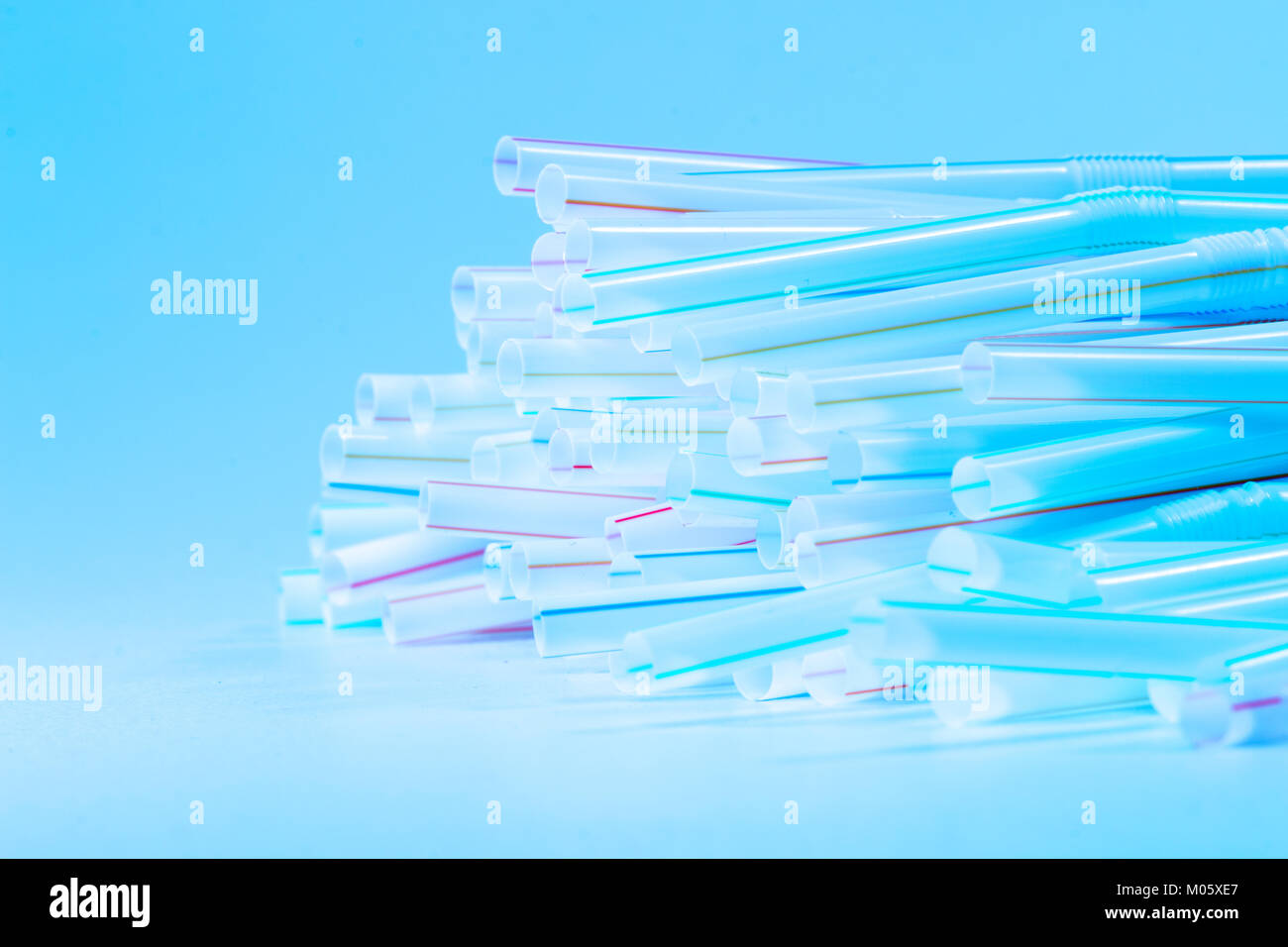 Bunch of drinking straws isolated on a blue background Stock Photo - Alamy