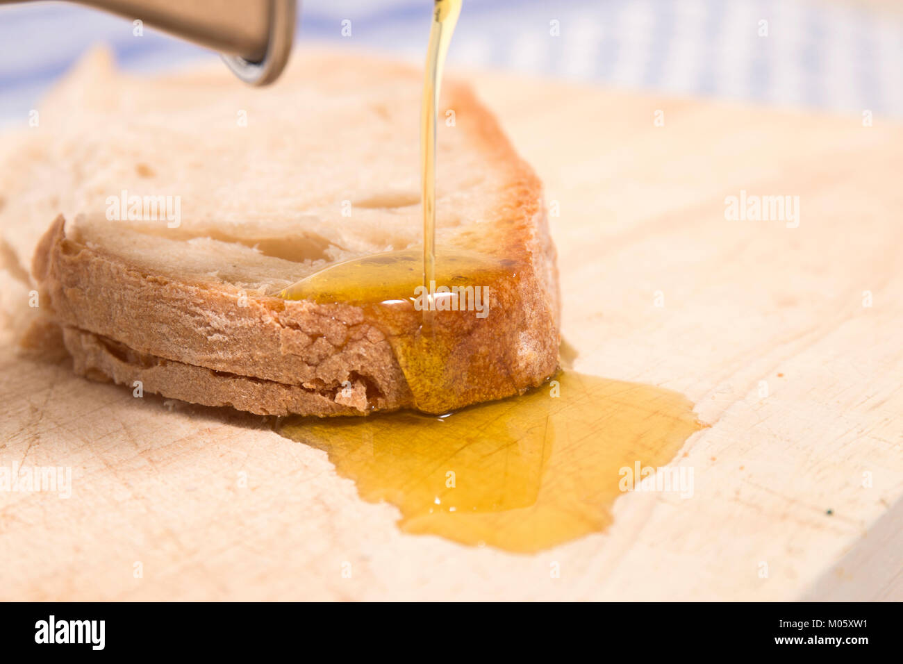 Pouring virgin olive oil on traditional Portuguese bread Stock Photo