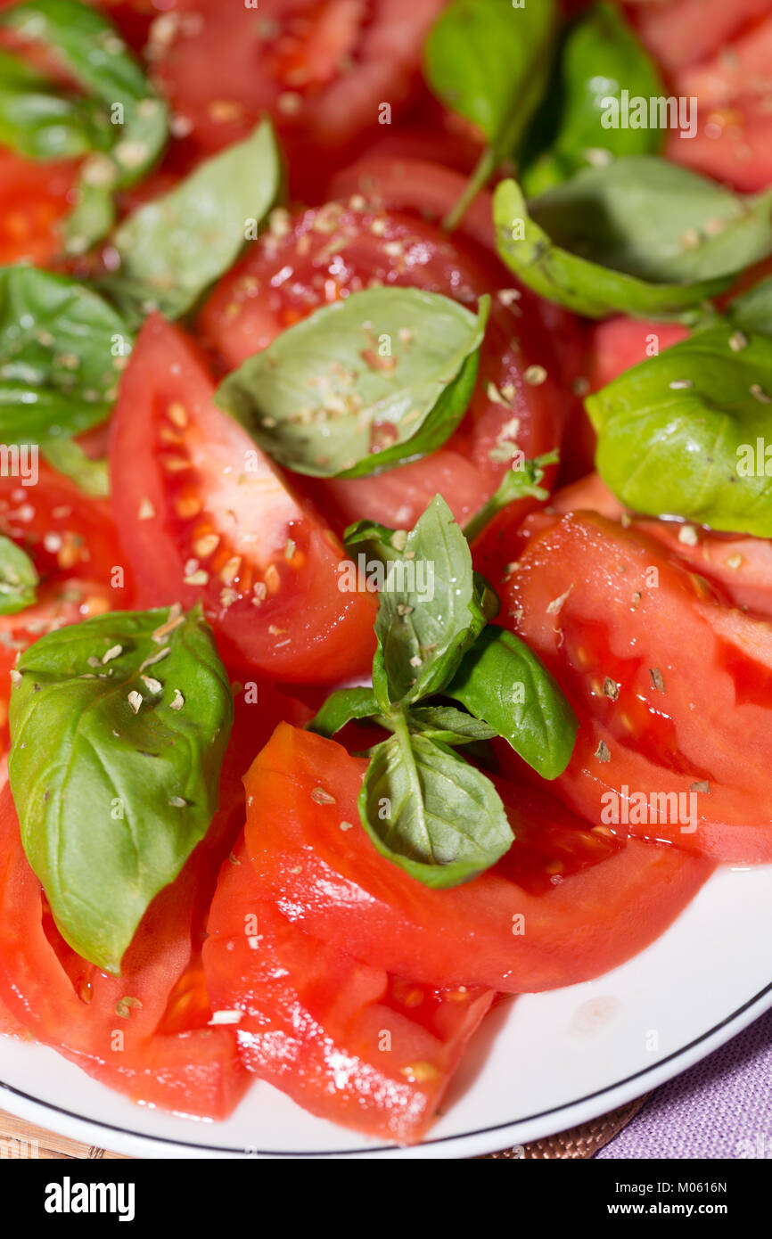 sliced of tomatoes with basil Stock Photo - Alamy