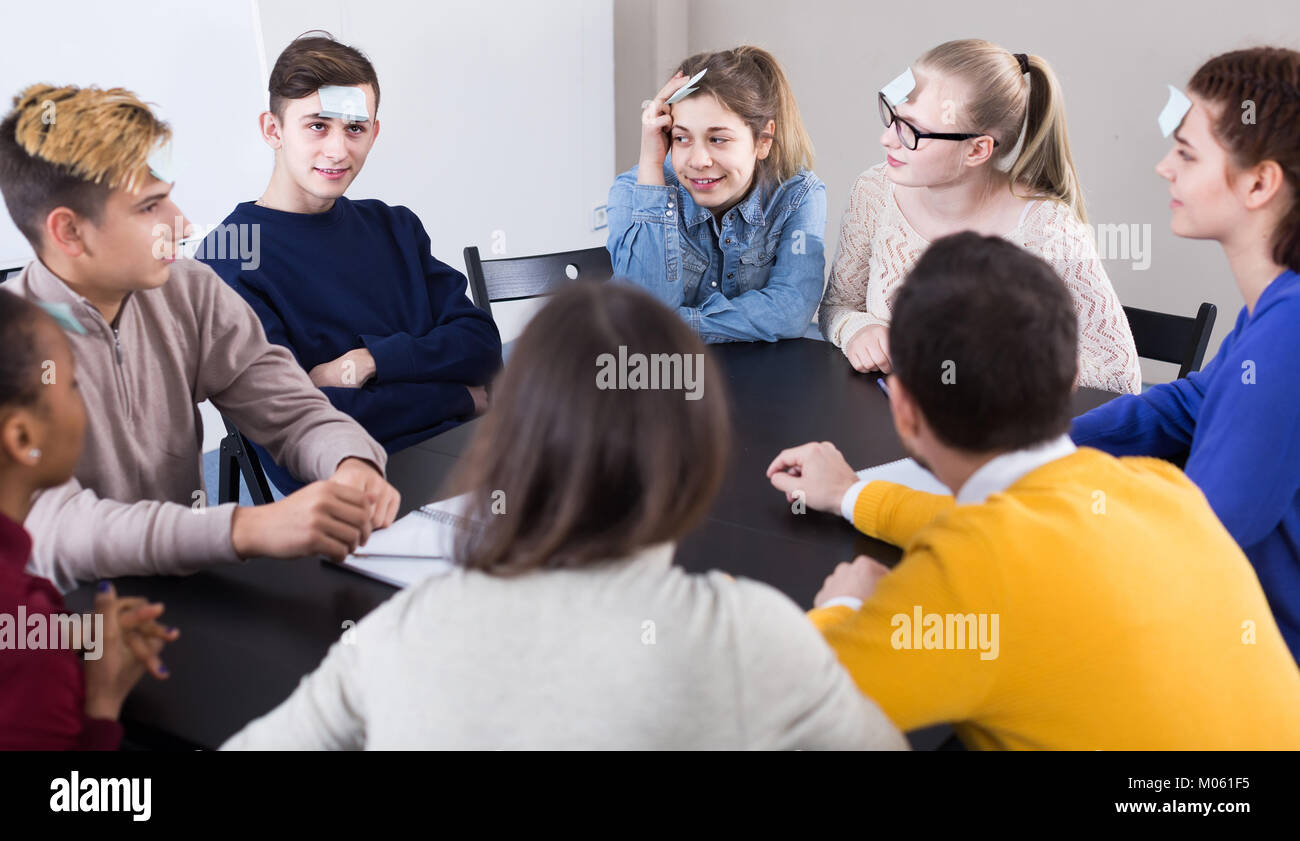 smiling classmates having round of guesswho game during class Stock Photo Alamy
