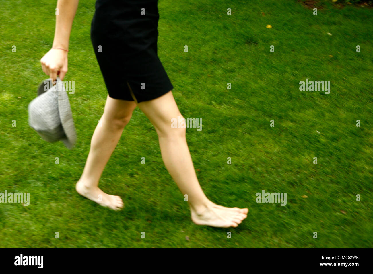 Woman walking barefoot grass legs hi-res stock photography and images ...