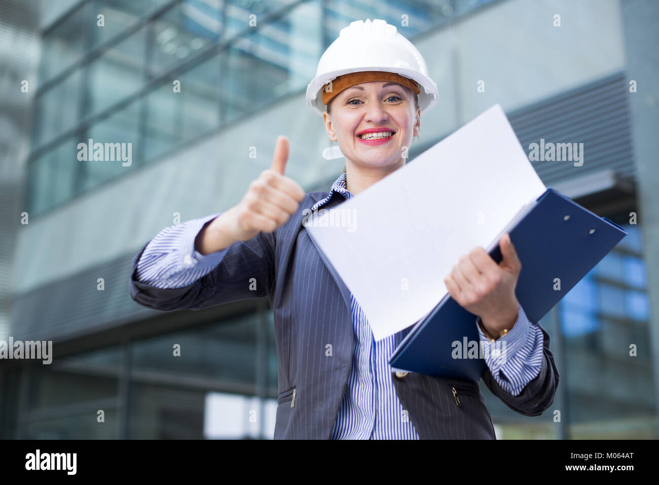 Professional woman in jacket and helmet working with documents Stock ...
