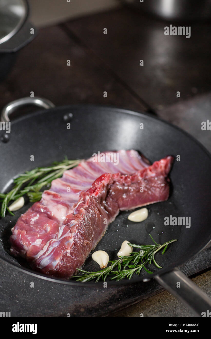 fried ribs of lamb. add a sprig of rosemary and garlic. Cooking with fire in frying pan