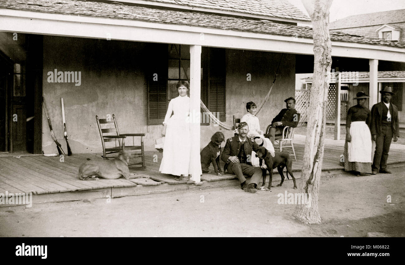 Two soldiers and two women on porch, with Afro-American woman and man to right, Fort Verde, Arizona Stock Photo