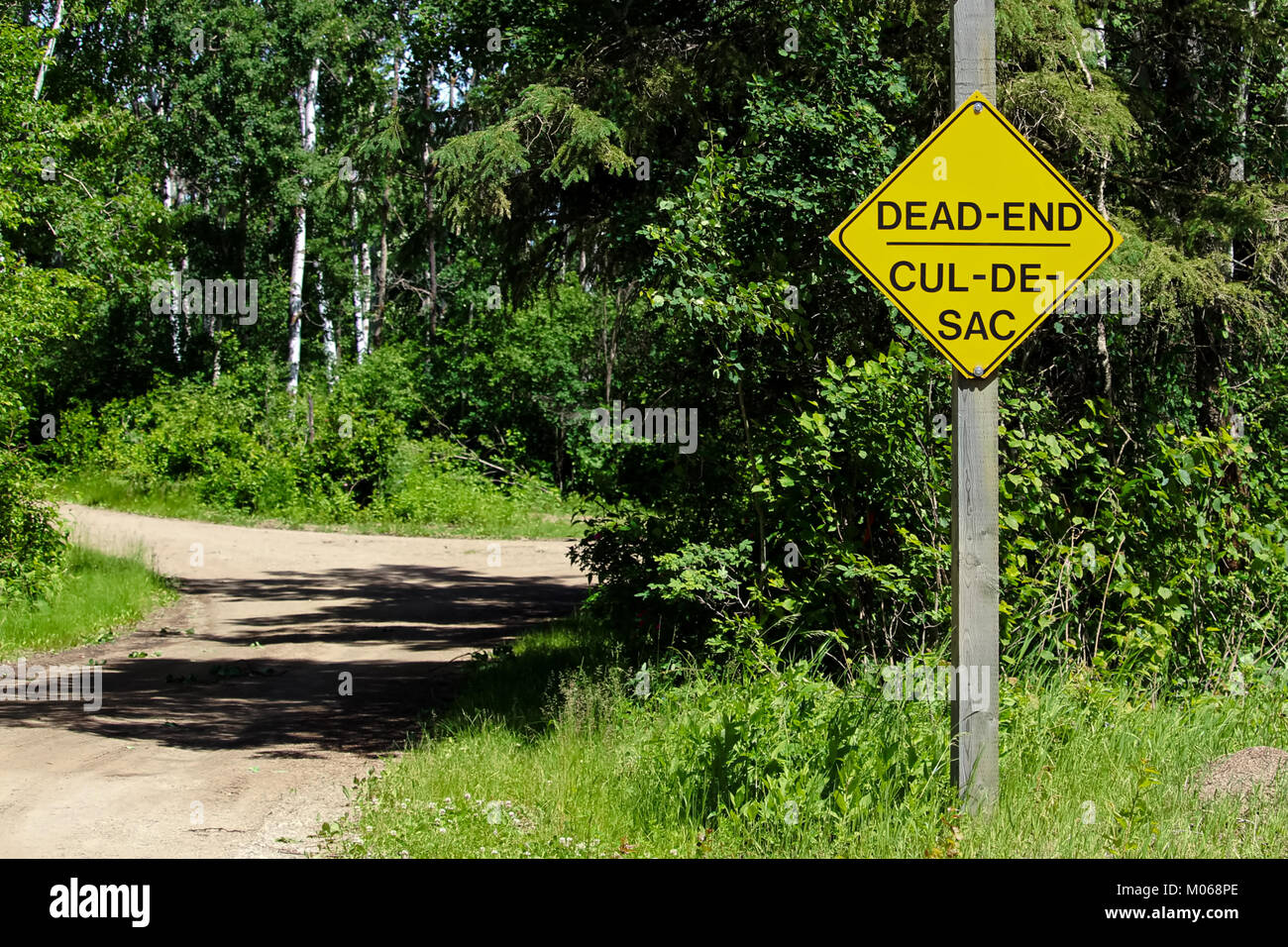 A Dead End sign beside a gravel road Stock Photo
