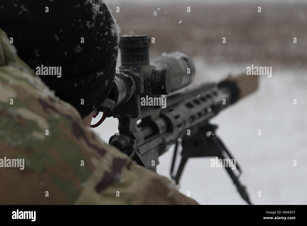 A U.S. Soldier assigned to Headquarters and Headquarters' Troop sniper  section, 3rd Squadron, 2nd Cavalry Regiment, peers through the scope of his  M2010 rifle as he acquires his target at a range