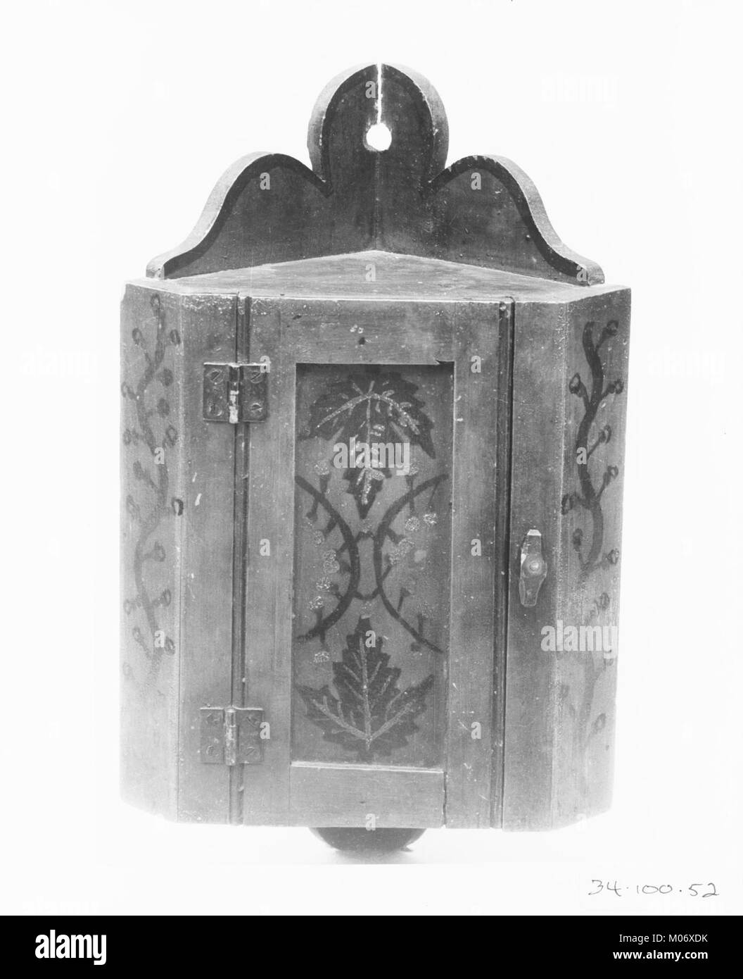 This key cupboard is a historical piece designed for storing keys. Its craftsmanship reflects the period's design preferences, showcasing detailed woodwork and functional design. Stock Photo