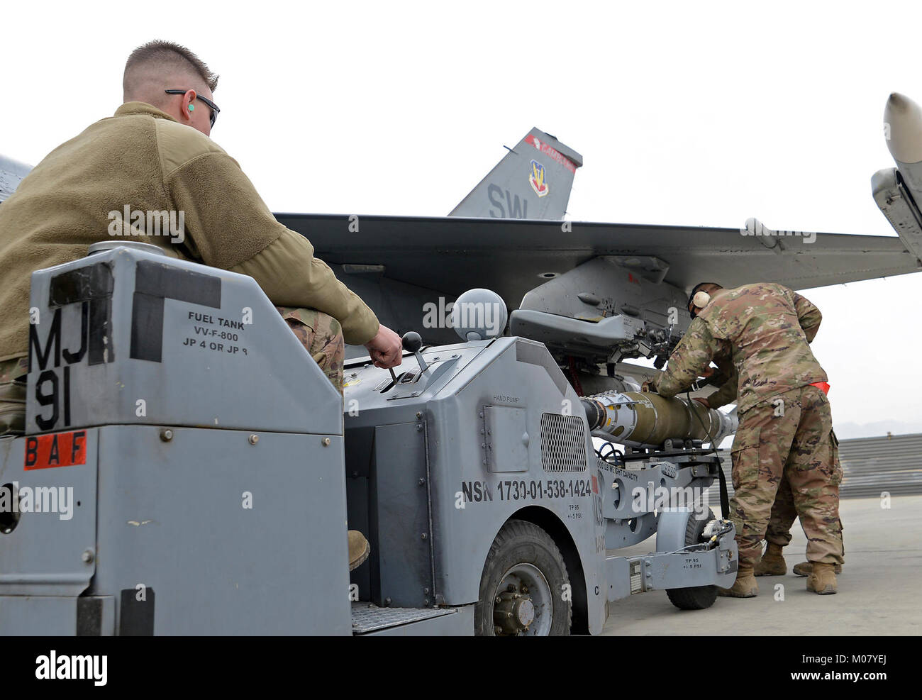 Senior Airman Kaleb Linn, 455th Expeditionary Aircraft Maintenance Squadron weapons load crew member, loads a munition onto an F-16 Fighting Falcon using a jammer Jan. 4, 2018 at Bagram Airfield, Afghanistan. Linn is responsible for maintaining the weapon's system on the F-16 as well as performing the weapons loads. (U.S. Air Force Stock Photo