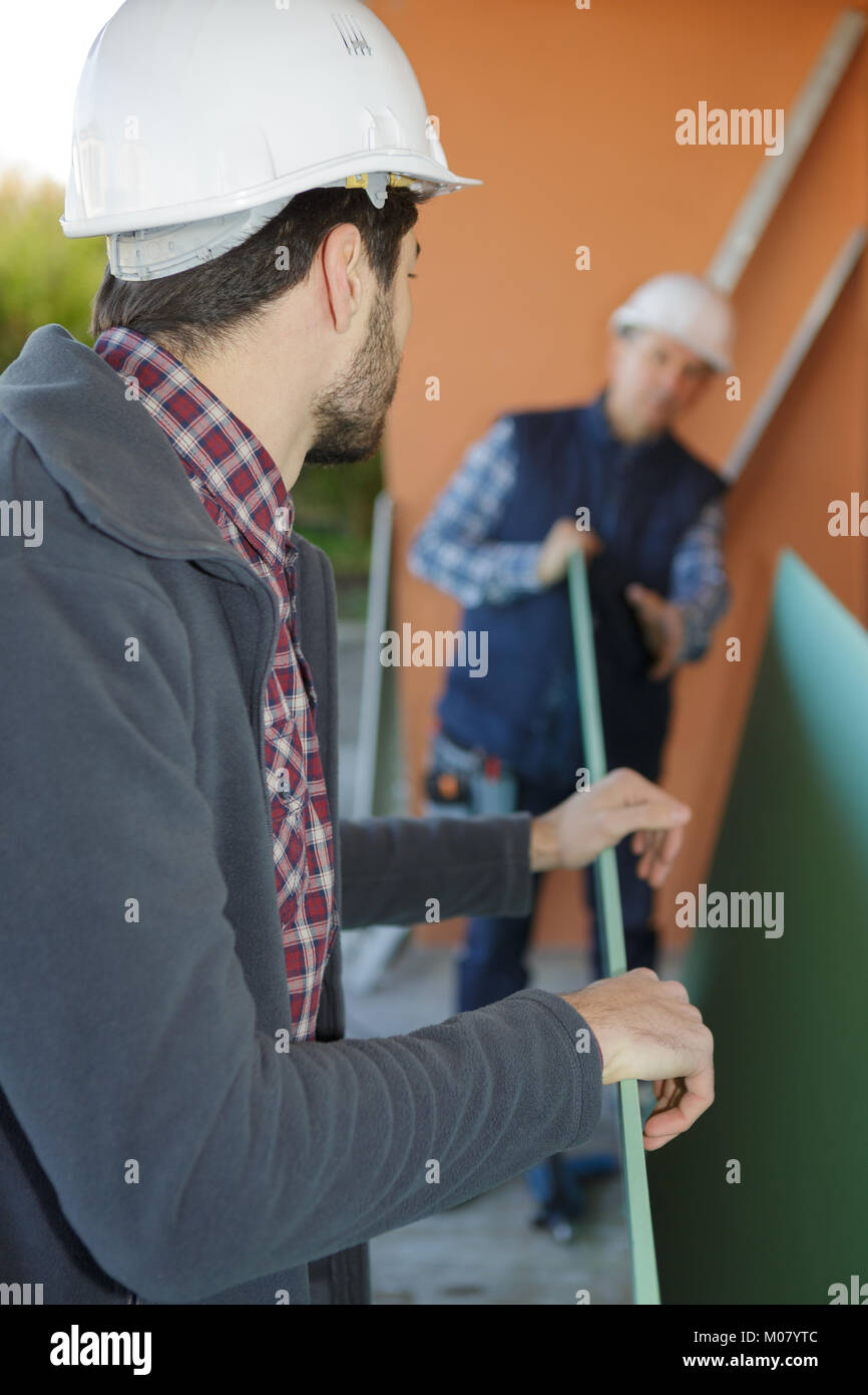 two workers moving boards inside Stock Photo Alamy