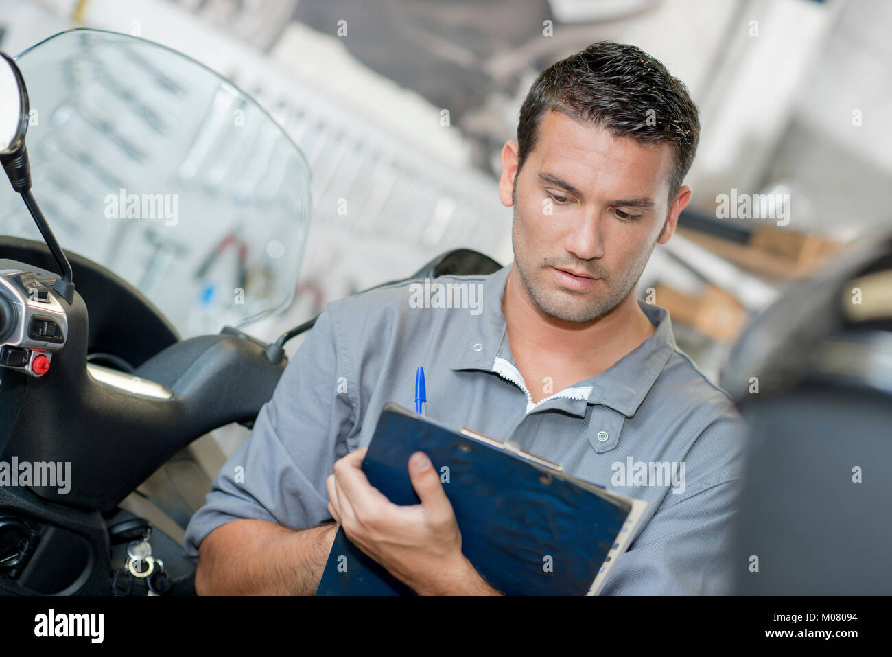 Driver Making Notes Mechanic making notes on clipboard Stock Photo - Alamy