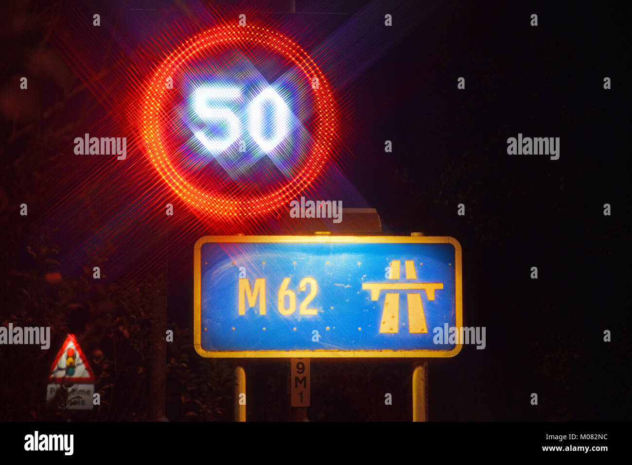reduced 50mph speed limit warning sign on the M62 motorway at night
