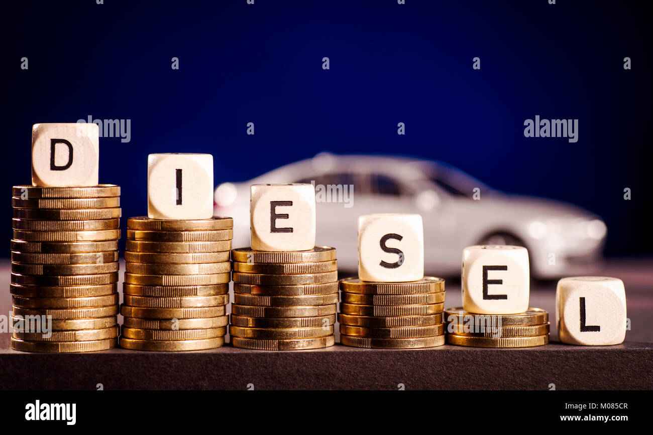 Stacks of coins and the word diesel with a car in the background Stock Photo