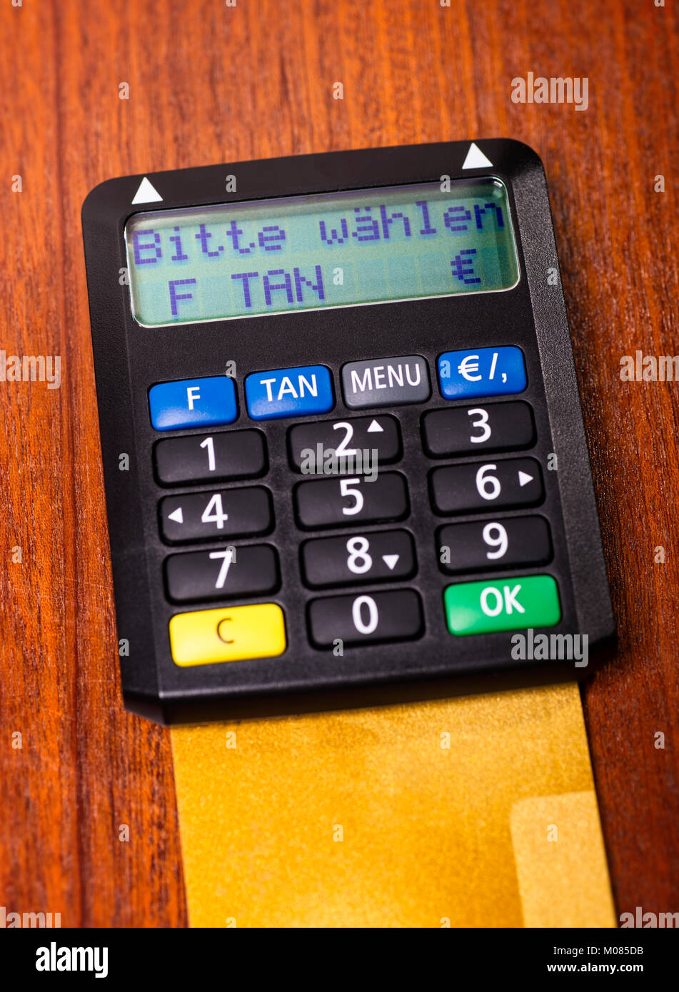 Tan generator with credit card lying on a desk and the request 'please select' on the display Stock Photo