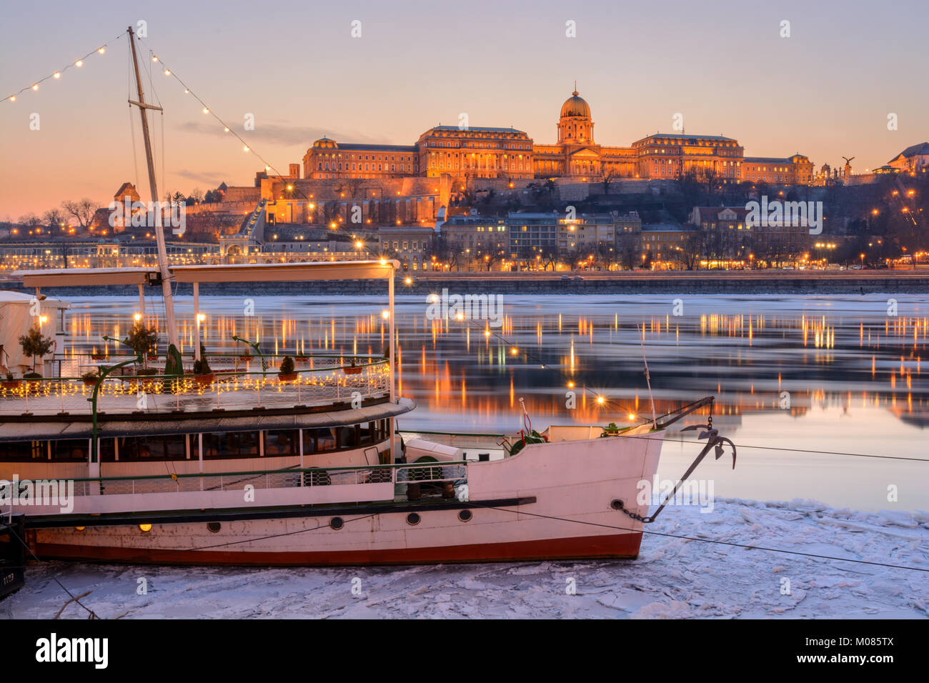 Illuminated boat against Royal palace in Budapest Stock Photo