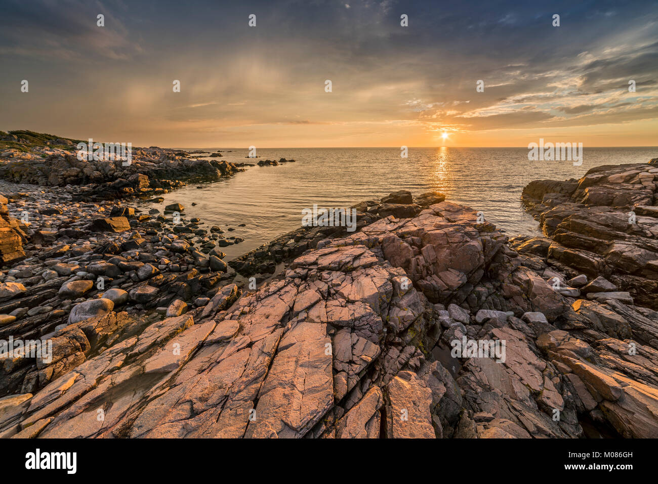 Sunset over the sea and the rocks at the beach at Hovs Hallar nature reserve on the Bjare Peninsula, Bastad, Skane, Sweden, Scandinavia. Stock Photo