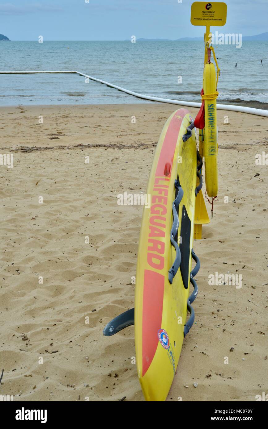 Surf life saving flags and paddle board at a stinger net