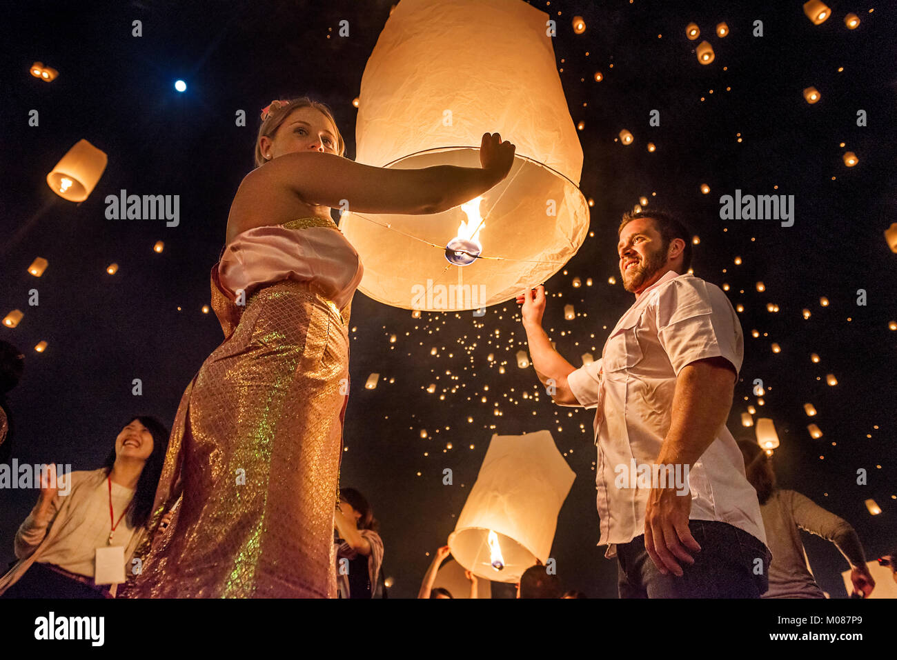 Couples happily releasing lantern in the sky, Yi Peng festival, Chiang Mai, Thailand Stock Photo