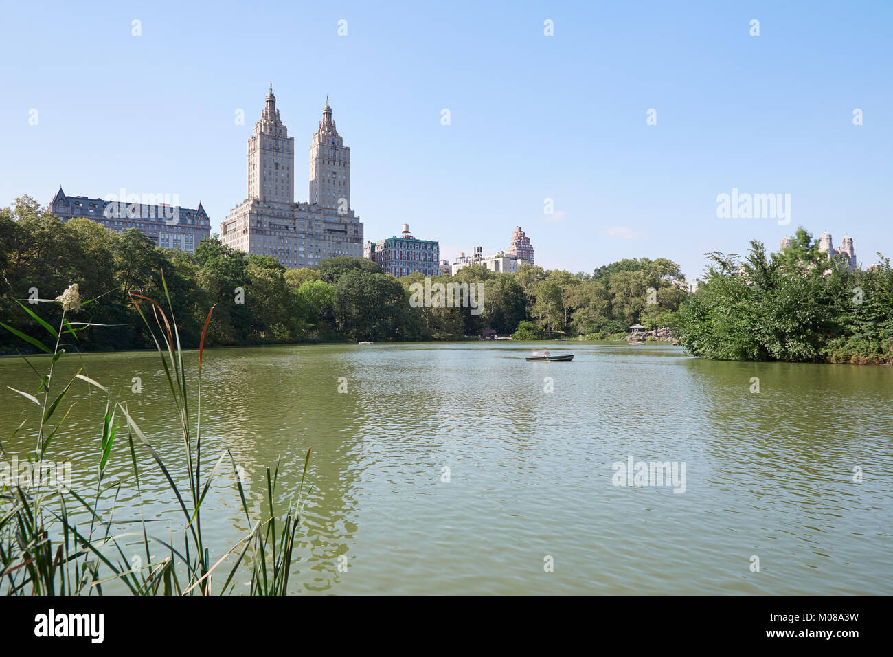 Central Park pond in New York with boat and the San Remo building, blue sky in a sunny day Stock Photo