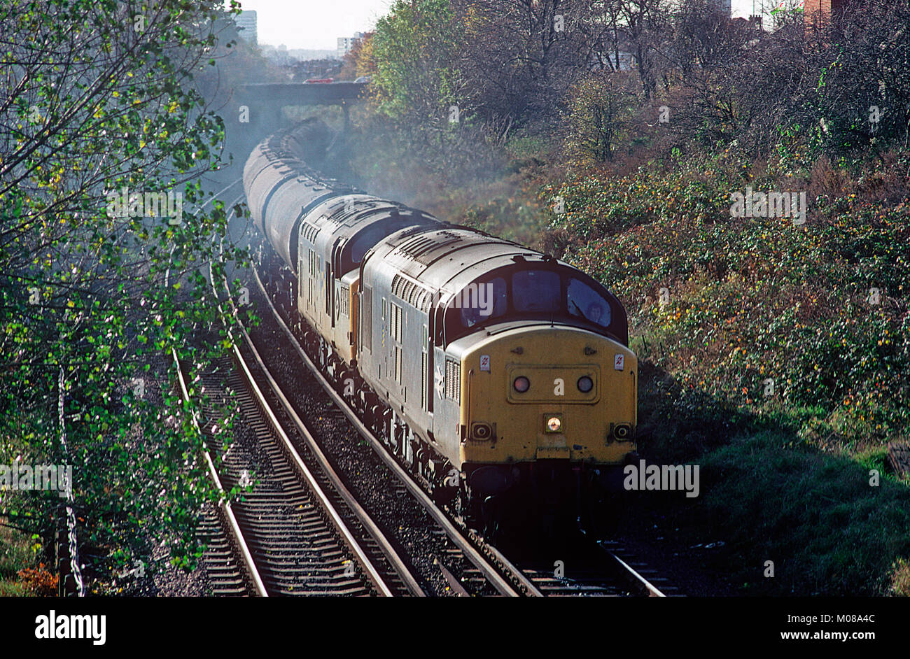 A pair of class 37 diesel locomotives numbers 37162 and 37220 with a train of bogie oil tanks approaching Acton Wells Junction in west London. 12th November 1992. Stock Photo