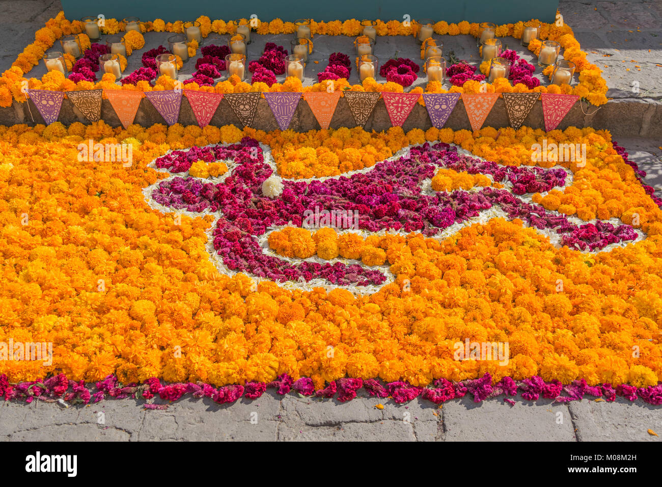 On the ground, an array of orange and red marigold flowers in the shape