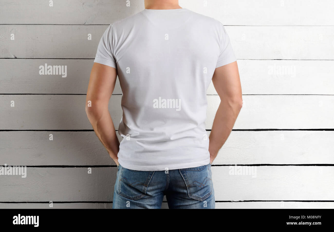 Rear view on the back of an athletic Caucasian guy in a white T-shirt ...