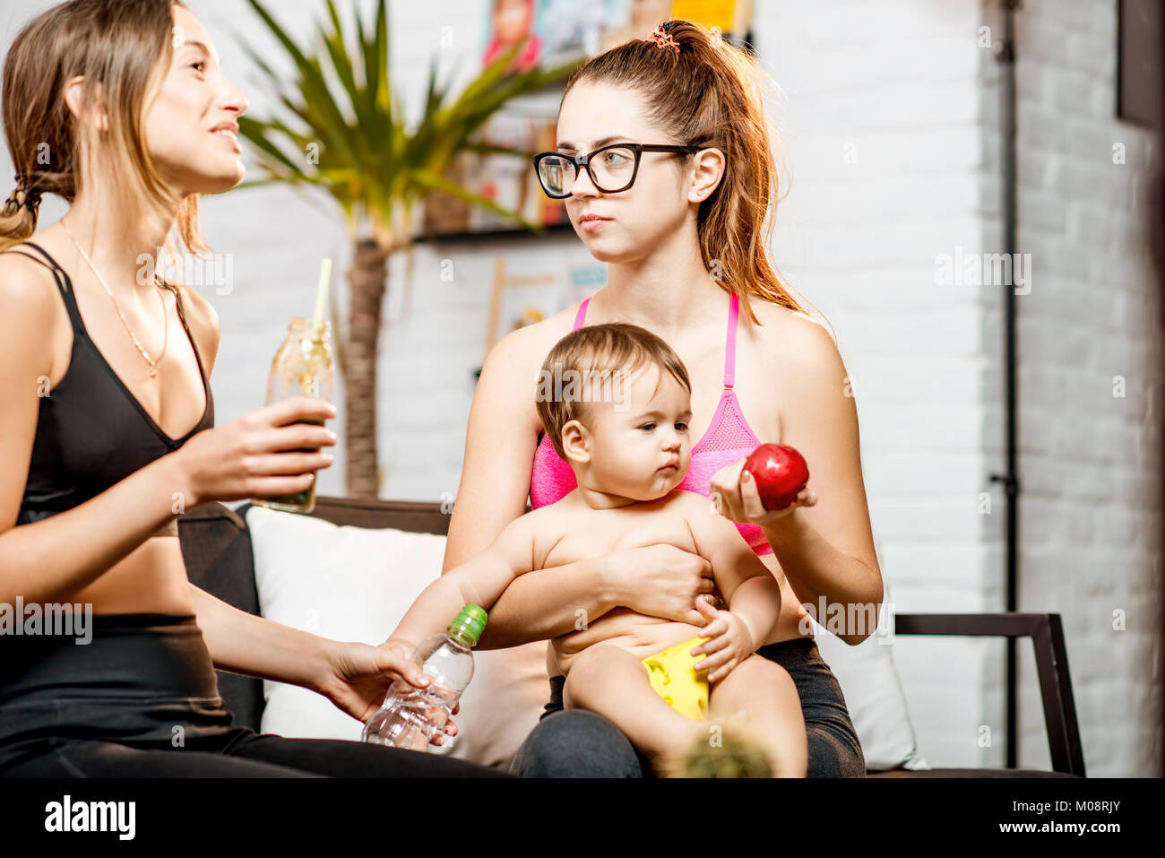 Sports moms with baby boy at home Stock Photo